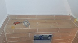 Badsanierung mit Feinsteinzeug in Terrazzo-Optik, Ziegelformat-Wandfliesen und Vorwand mit präzisen Gehrungsschnitten – für eine nahtlose, hochwertige Gesamtoptik 2